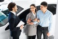 Couple Taking Key From Salesman In Auto Showroom Royalty Free Stock Photo