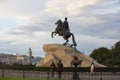 Couple taking photos by Bronze Horseman equestrian sculpture of Peter the Great on blue sky and white clouds background