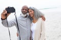 Couple taking a picture with digital camera on the beach Royalty Free Stock Photo