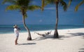 Couple taking picture at the perfect beach on hammock, Maldives Royalty Free Stock Photo