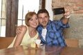 Couple taking selfie photo with mobile phone at coffee shop smiling happy in romance love concept Royalty Free Stock Photo