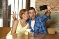 Couple taking selfie photo with mobile phone at coffee shop smiling happy in romance love concept Royalty Free Stock Photo