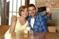 Couple taking selfie photo with mobile phone at coffee shop smiling happy in romance love concept Royalty Free Stock Photo