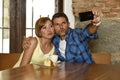 Couple taking selfie photo with mobile phone at coffee shop smiling happy in romance love concept Royalty Free Stock Photo