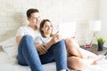 Couple Taking Selfportrait On Tablet Computer On Bed