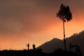 A couple taking shots of sunset using a handphone and a camera