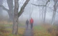 A couple taking a walk on path in heavy fog