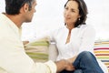 Couple talking together on sofa at home