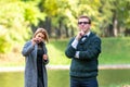Couple talking seriously outdoors in a park with a green background Royalty Free Stock Photo
