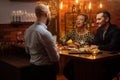 Couple talking to bartender behind bar counter in a cafe