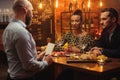 Couple talking to bartender behind bar counter in a cafe