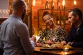 Couple talking to bartender behind bar counter in a cafe