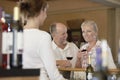 Couple Tasting Wine With Merchant In Foreground