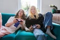 Couple of teenage friends playing with video game console Royalty Free Stock Photo