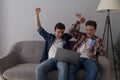 Two guys with laptop on sofa. Royalty Free Stock Photo