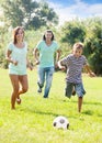 Couple and teenager boy playing with soccer ball