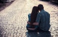 Couple of teenagers sit in street together Royalty Free Stock Photo