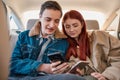 A couple of teenagers using their smartphones while sitting on back seat in the car Royalty Free Stock Photo