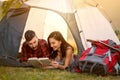 Couple in tent reading a book