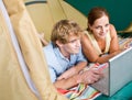 Couple in tent using laptop Royalty Free Stock Photo