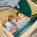 Couple in tent using laptop