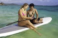 Couple texting on a paddle board