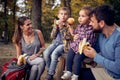 A couple and their children enjoying eating fruits in the forest