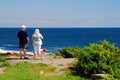 A couple and their pet take in the view of the Maine Coast