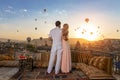 A couple and their romantic breakfast in Cappadocia on the amazing background of hundred flying balloons