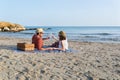 Couple toasting while holding hands on a mediterranean beach at sunset