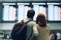 couple tourist looking at flight schedules for checking take off time. Generative AI