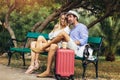 Couple of tourist listening music with a tablet sitting in a bench in the park Royalty Free Stock Photo