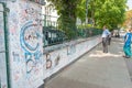 Couple of tourists on Abbey Road outside famous studios looking over grafitti covered wall