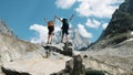 Couple of tourists with backpacks in the campaign raise their hands up on the top of the mountains. Concept of victory Royalty Free Stock Photo