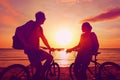 Couple tourists with Bicycles Watching Sunset. Silhouette people