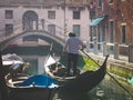 Couple of tourists enjoying gondola tour in the water channel of