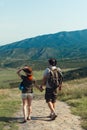 A couple of tourists in hats, a man with a backpack. walk against the backdrop of the mountains. Mtskheta. Georgia. Vertical photo Royalty Free Stock Photo