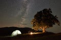 Couple tourists at night camp in mountains under starry sky Royalty Free Stock Photo