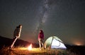 Couple tourists at night camp in mountains under starry sky Royalty Free Stock Photo