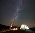 Couple tourists at night camp in mountains under starry sky Royalty Free Stock Photo