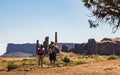 Couple of tourists taking pictures at Three Sisters, Monument Valley