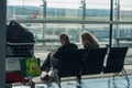 Couple of tourists waiting in boarding hall with a suitcase at the airport Royalty Free Stock Photo