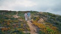 Couple tourists walking hill holding by hands. Family pair enjoy active vacation