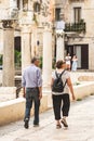 Couple of tourists walking among the remains and columns of a Roman Temple in Bari old town