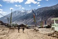 Couple tourists walking on the yellow stone ground to black mountain with snow on the top at Thangu and Chopta valley in winter. Royalty Free Stock Photo