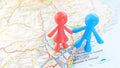 A couple of toy figures holding hands standing on a map of Barcelona