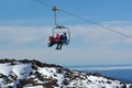 Couple travel on Ski lift to top of Mount Ruapehu