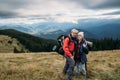 Couple traveler with backpacks in the alps, hikers in the mountains, happy active lifestyle, hiking man and woman Royalty Free Stock Photo