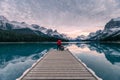 Couple traveler relaxing on wooden pier in Maligne lake at Spirit island, Jasper national park Royalty Free Stock Photo