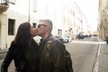 Couple of travelers are kissing in the street. Man and woman are wearing in casual clothing. Leather jacket for both. Sunglasses Royalty Free Stock Photo